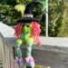 Witch.  Nellie the rainbow witch sits on balcony outside